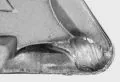 Macro shot of an insert: crater wear on the rake face, washed out by the chip at a distance from the edge